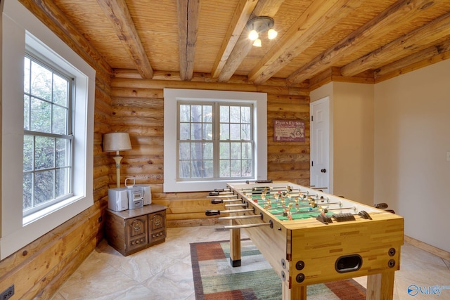 recreation room featuring beamed ceiling, a wealth of natural light, rustic walls, and wood ceiling