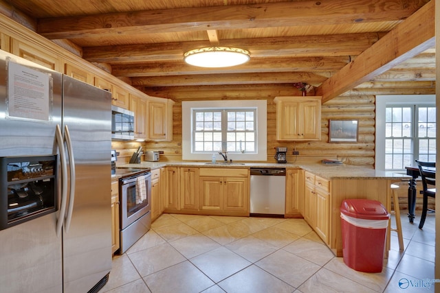 kitchen featuring stainless steel appliances, sink, light brown cabinets, and rustic walls