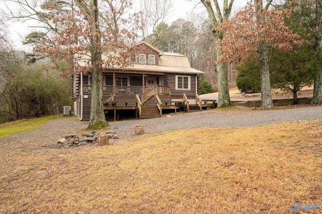 log home featuring a wooden deck, a front yard, and central air condition unit