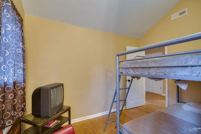 bedroom featuring hardwood / wood-style flooring and lofted ceiling