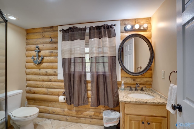 bathroom with toilet, vanity, log walls, and tile patterned flooring