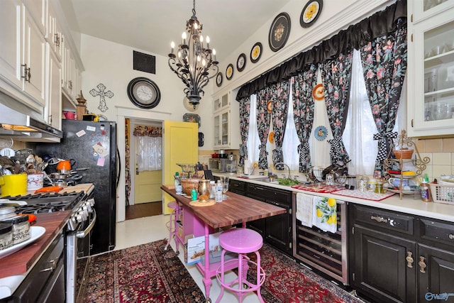 kitchen with wooden counters, decorative backsplash, high end stove, sink, and white cabinets