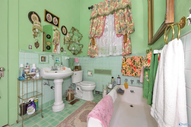 bathroom with a washtub, sink, tile walls, tile patterned flooring, and toilet