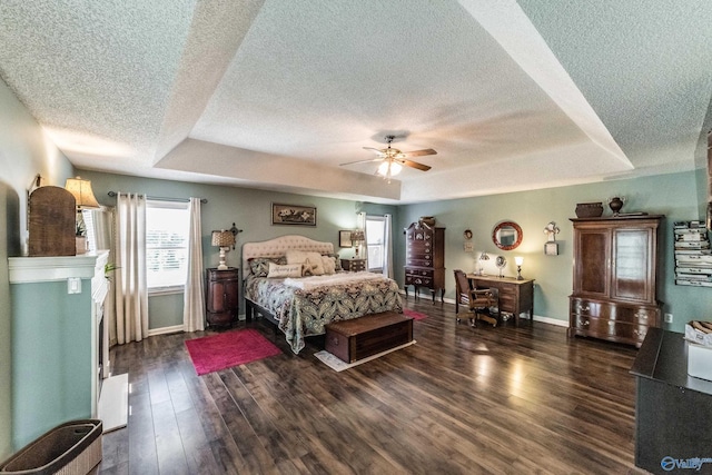 bedroom with a raised ceiling, ceiling fan, a textured ceiling, and dark hardwood / wood-style floors