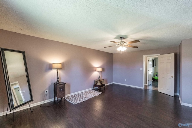 unfurnished living room with ceiling fan, dark hardwood / wood-style flooring, and a textured ceiling