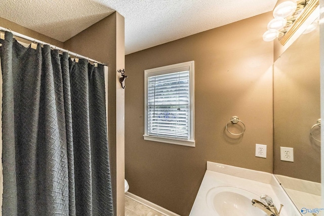 bathroom featuring vanity, curtained shower, toilet, and a textured ceiling