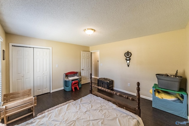 bedroom with a textured ceiling, a closet, and dark hardwood / wood-style floors