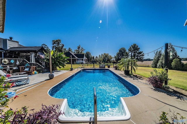 view of pool with a yard and a patio