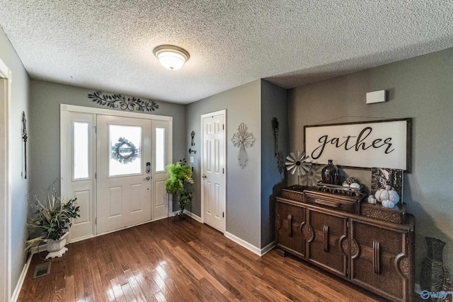 foyer entrance featuring dark hardwood / wood-style flooring and a textured ceiling