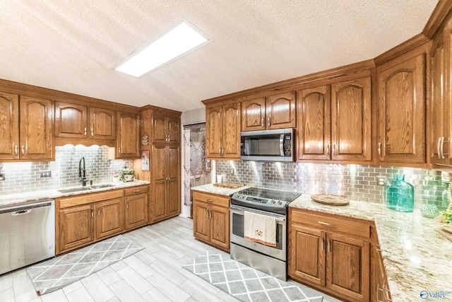 kitchen with stainless steel appliances, tasteful backsplash, light hardwood / wood-style floors, and sink