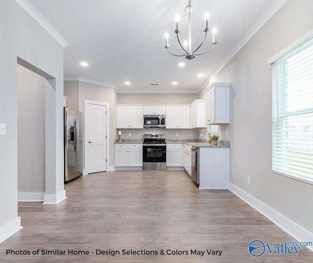 1112 Hine St, Athens, AL 35611 - kitchen featuring hanging light fixtures, appliances with stainless steel finishes, a wealth of natural light, and white cabinets