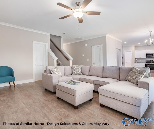 1112 Hine St, Athens, AL 35611 - living room with ceiling fan with notable chandelier, ornamental molding, and light wood-type flooring