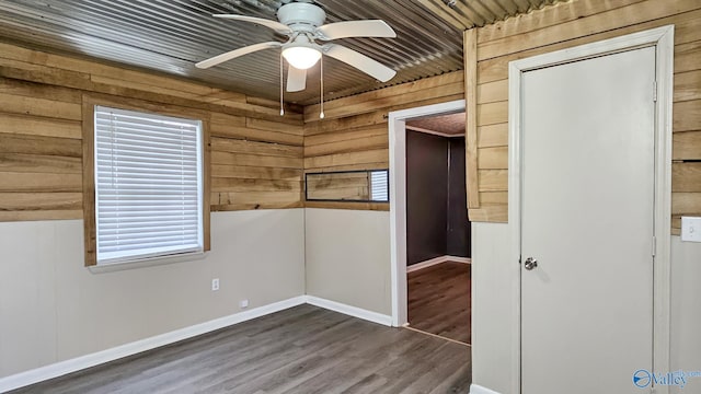 18222 Mcmunn Ln, Athens, AL 35614 - unfurnished room featuring dark wood-type flooring, ceiling fan, and wooden walls