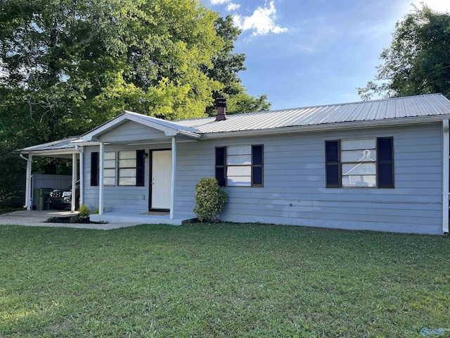 single story home with metal roof, a front lawn, and an attached carport