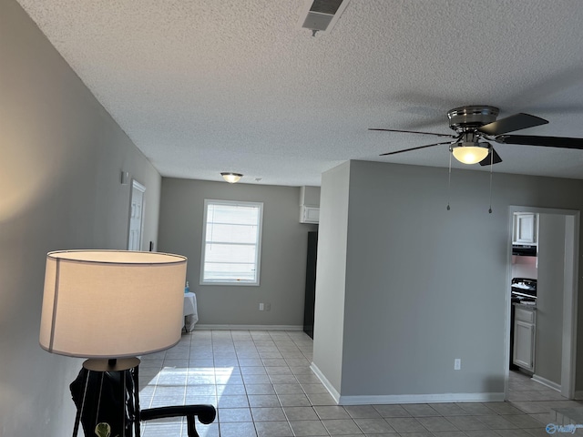 kitchen with baseboards, a textured ceiling, and light tile patterned flooring