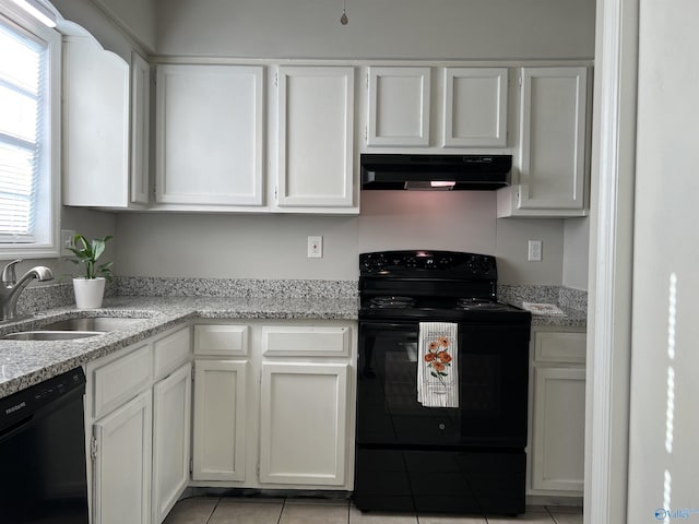 kitchen featuring light tile patterned floors, white cabinets, under cabinet range hood, black appliances, and a sink