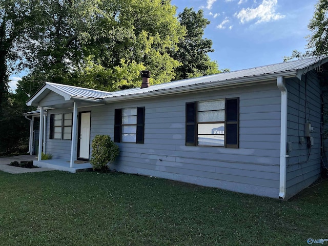 single story home with metal roof and a front lawn