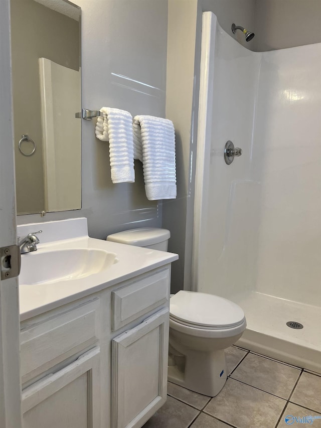 full bath with toilet, a stall shower, tile patterned flooring, and vanity