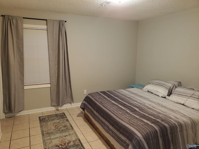 bedroom featuring light tile patterned floors and a textured ceiling