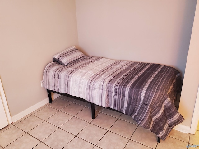 bedroom with light tile patterned floors and baseboards