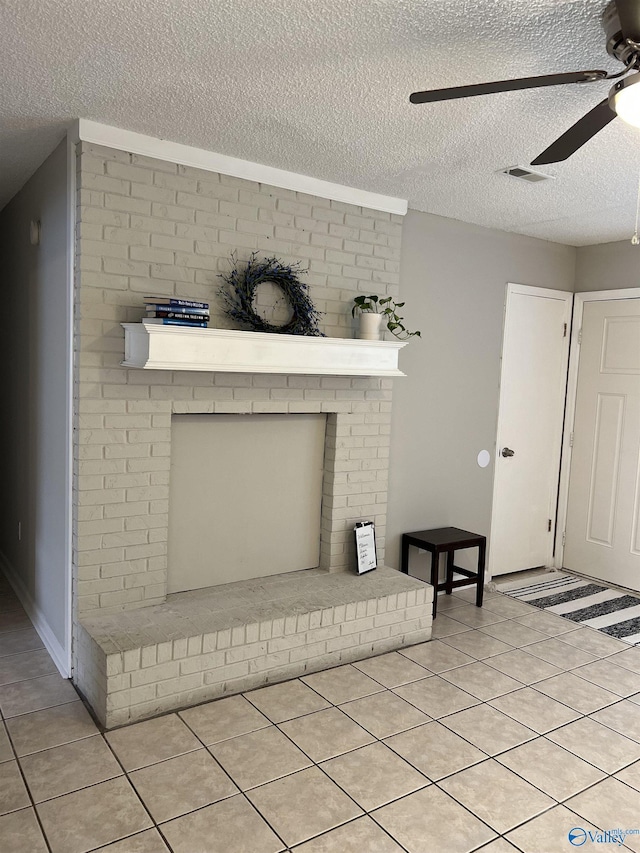 room details featuring a ceiling fan, a brick fireplace, visible vents, and a textured ceiling