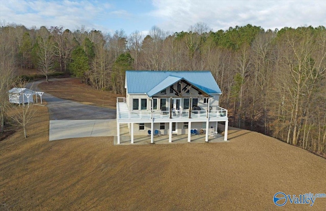 view of front facade featuring a patio, a wooden deck, and a front lawn