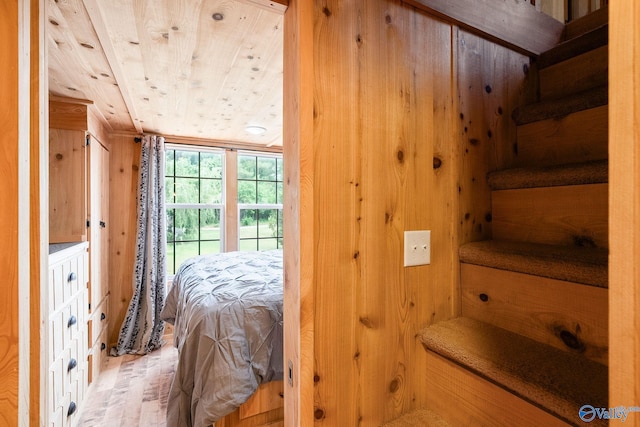 bedroom featuring wooden walls and wood ceiling