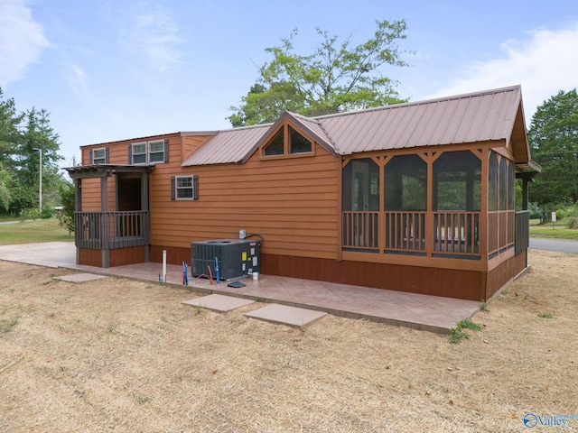 rear view of property featuring cooling unit and a patio area