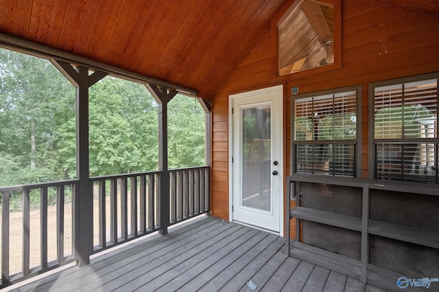 unfurnished sunroom featuring vaulted ceiling, wood ceiling, and a wealth of natural light