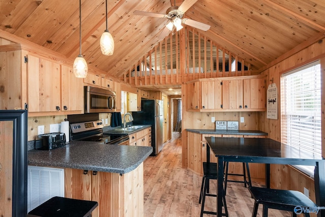 kitchen with stainless steel appliances, hanging light fixtures, high vaulted ceiling, light brown cabinets, and light hardwood / wood-style floors