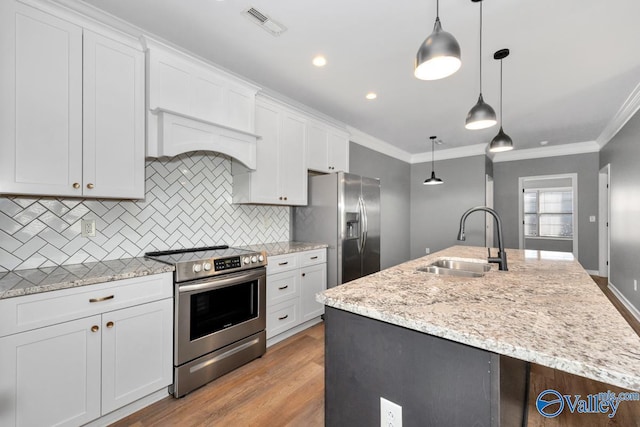 kitchen with pendant lighting, sink, an island with sink, appliances with stainless steel finishes, and white cabinetry