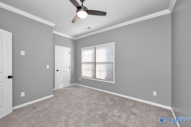 carpeted spare room with ceiling fan and crown molding