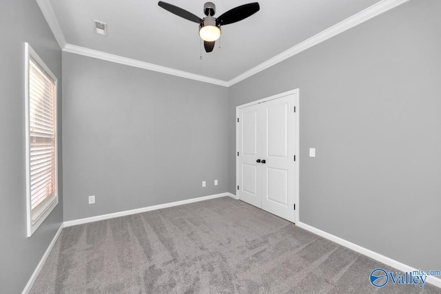 carpeted empty room featuring ceiling fan and crown molding