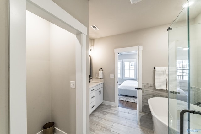 bathroom featuring tile walls, vanity, and plus walk in shower