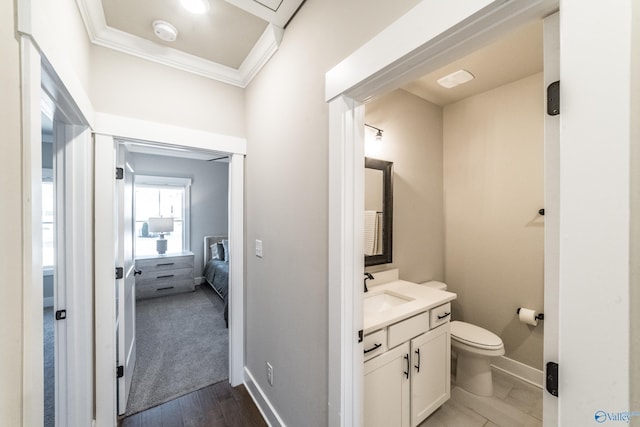 bathroom featuring hardwood / wood-style flooring, toilet, vanity, and crown molding