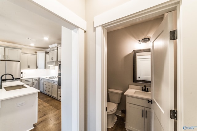 bathroom with toilet, ornamental molding, hardwood / wood-style floors, and vanity