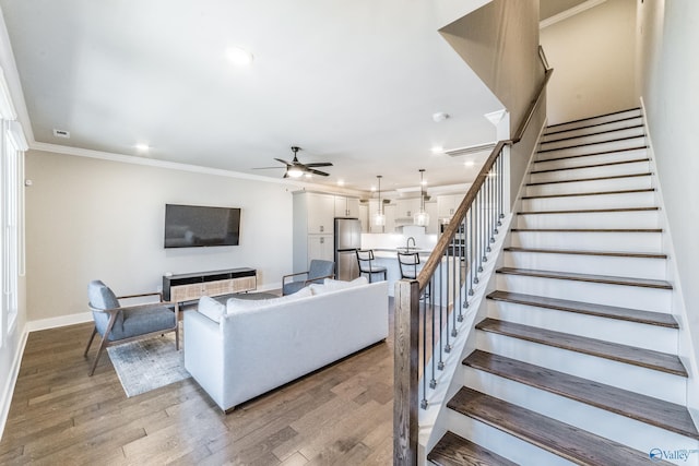 living room featuring a fireplace, ornamental molding, light hardwood / wood-style floors, and ceiling fan