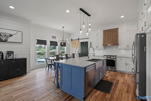 254 Whitlow Rd, Decatur, AL 35603 - kitchen featuring appliances with stainless steel finishes, a breakfast bar area, white cabinets, light wood-style floors, and light stone countertops