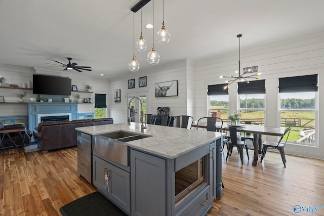 254 Whitlow Rd, Decatur, AL 35603 - kitchen featuring gray cabinetry, healthy amount of natural light, light wood-type flooring, and wood walls