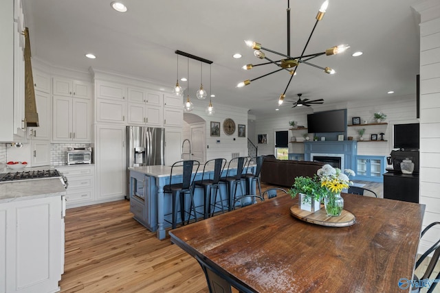 254 Whitlow Rd, Decatur, AL 35603 - dining space featuring a chandelier, light wood-style floors, a fireplace, recessed lighting, and crown molding