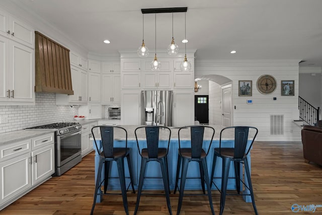 254 Whitlow Rd, Decatur, AL 35603 - kitchen featuring stainless steel appliances, ornamental molding, extractor fan, white cabinets, and a kitchen breakfast bar