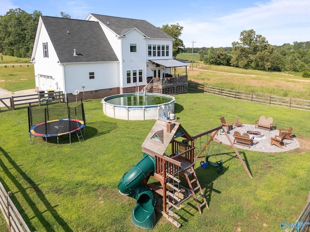 254 Whitlow Rd, Decatur, AL 35603 - back of property with a trampoline, an outdoor fire pit, a wooden deck, a fenced backyard, and a playground