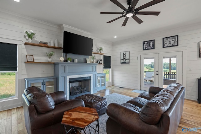 254 Whitlow Rd, Decatur, AL 35603 - living area featuring a premium fireplace, crown molding, light wood-type flooring, wood walls, and a ceiling fan