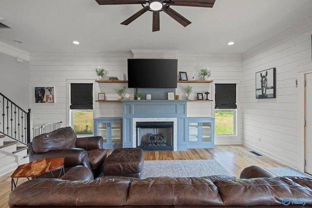254 Whitlow Rd, Decatur, AL 35603 - living room featuring wood finished floors, a ceiling fan, wooden walls, crown molding, and stairs
