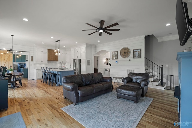 254 Whitlow Rd, Decatur, AL 35603 - living room with a ceiling fan, arched walkways, light wood-style floors, crown molding, and stairway