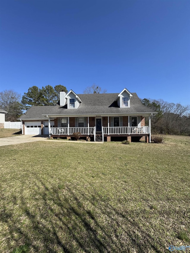 view of front of home with a garage, a front yard, and covered porch