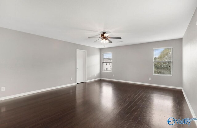 spare room with plenty of natural light, ceiling fan, and dark wood-type flooring