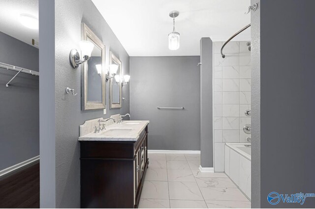 bathroom featuring tiled shower / bath combo and vanity