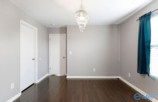 unfurnished bedroom featuring dark hardwood / wood-style floors and a notable chandelier