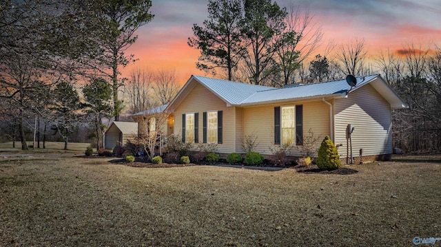 view of property exterior featuring metal roof and a lawn